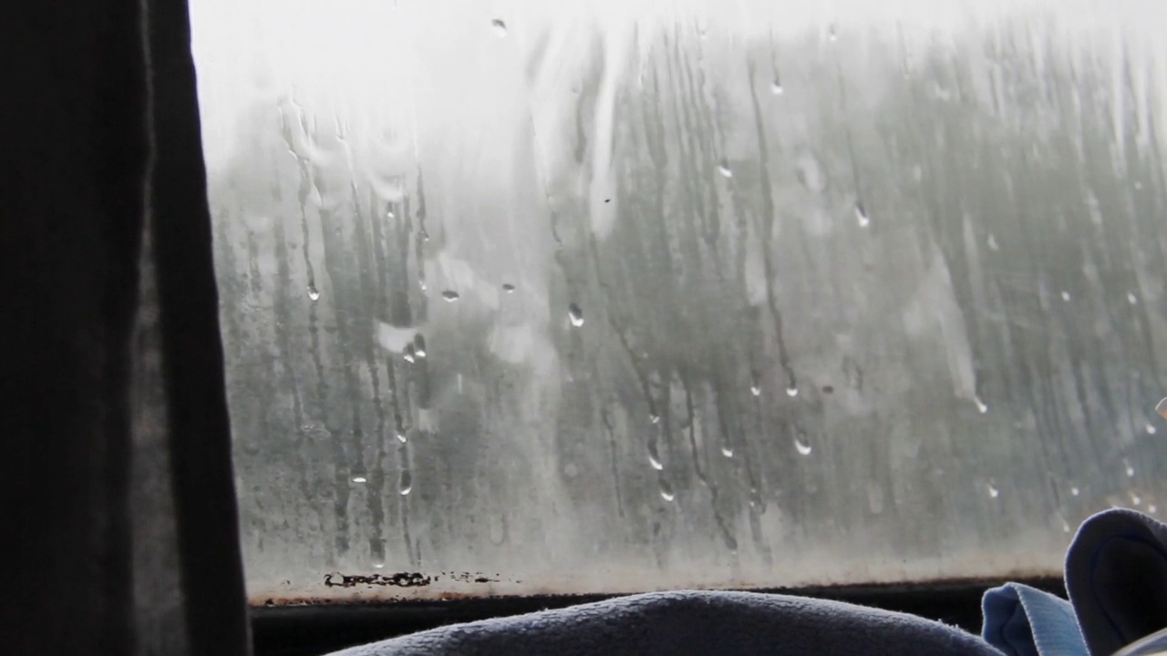 火车行驶时，雨滴落在肮脏的车窗上视频下载