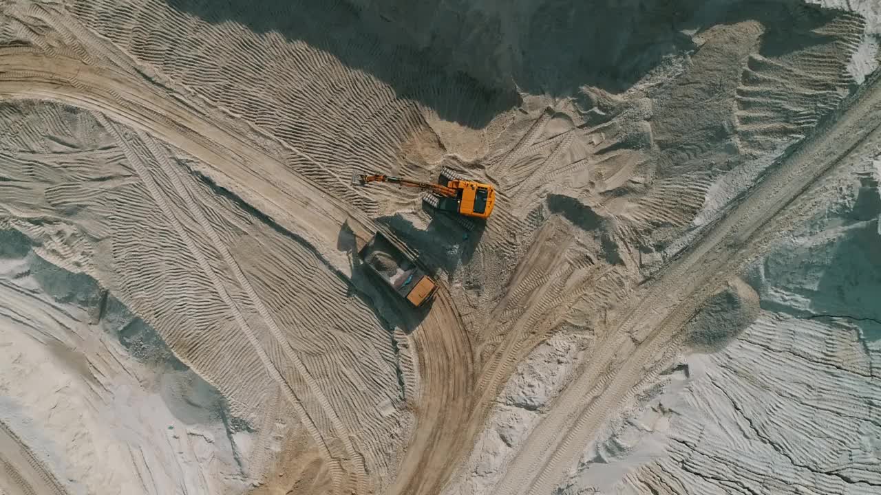 露天采石场，装载机将沙子装入重型自卸车。露天矿用自卸车运输砂石。采石场，从地下挖出砂石的采石场视频素材