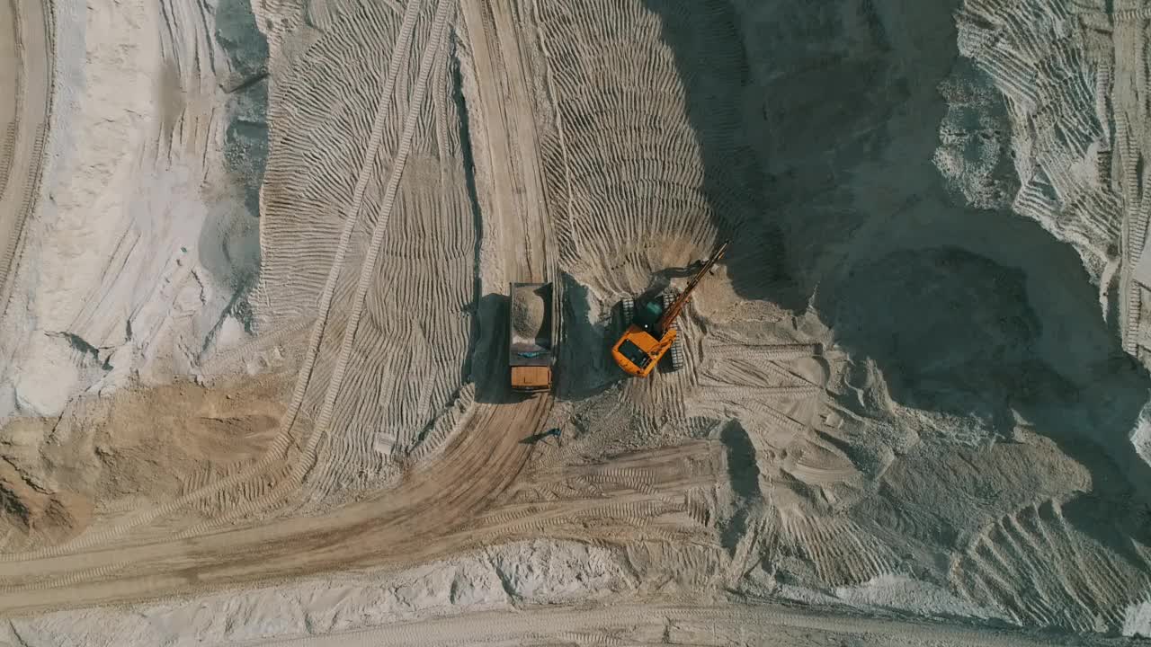 露天采石场，装载机将沙子装入重型自卸车。露天矿用自卸车运输砂石。采石场，从地下挖出砂石的采石场视频下载
