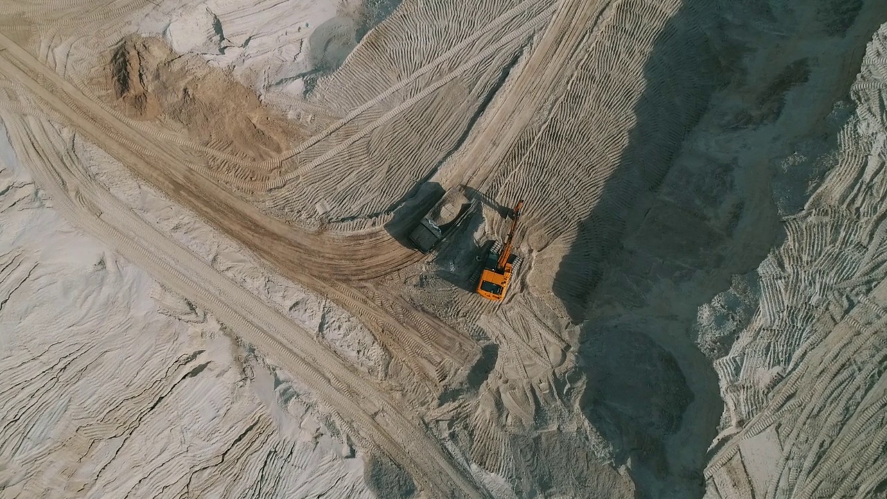 露天采石场，装载机将沙子装入重型自卸车。露天矿用自卸车运输砂石。采石场，从地下挖出砂石的采石场视频素材