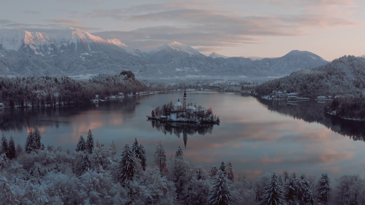 惊人的揭示镜头的湖布莱德，斯洛文尼亚在一个美丽的金色的早晨，在冬天的时间。背景中的雪山。宁静的自然，清新的空气，清澈的碧水。顶级旅游目的地。绿色的国家。视频下载