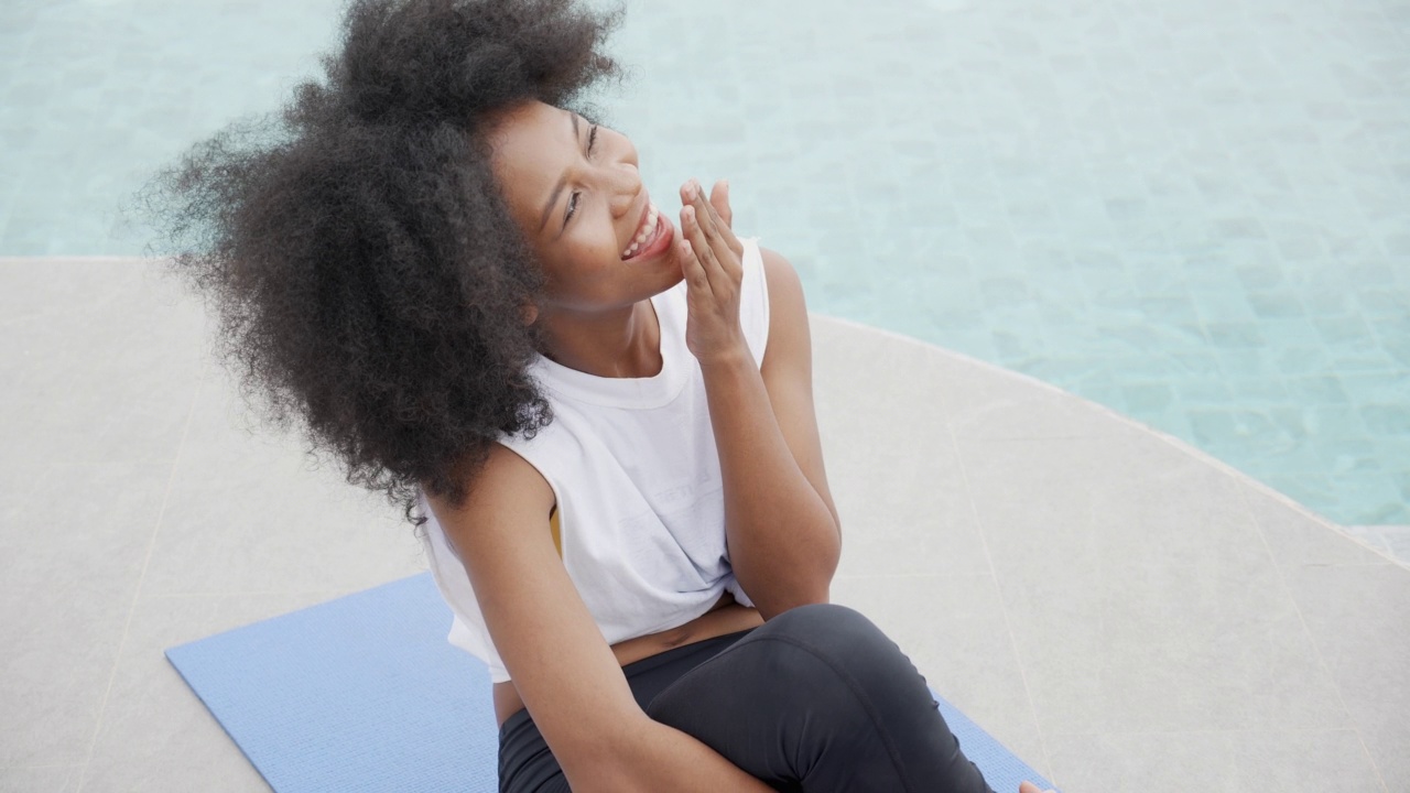 年轻的非洲裔美国妇女在泳池边微笑，女性放松和休闲，假期和夏天，一个人。视频下载