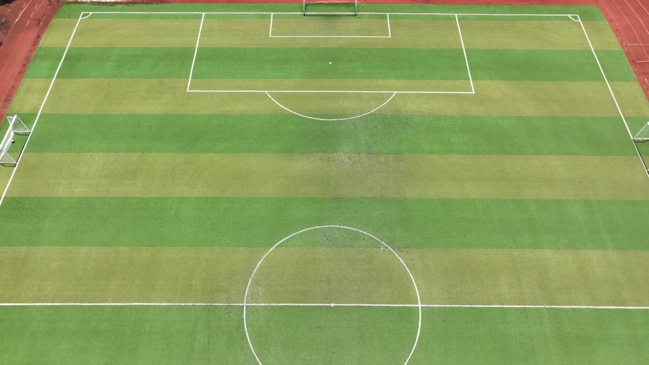阳光明媚的崭新空旷的足球场。无人机的鸟瞰图视频素材
