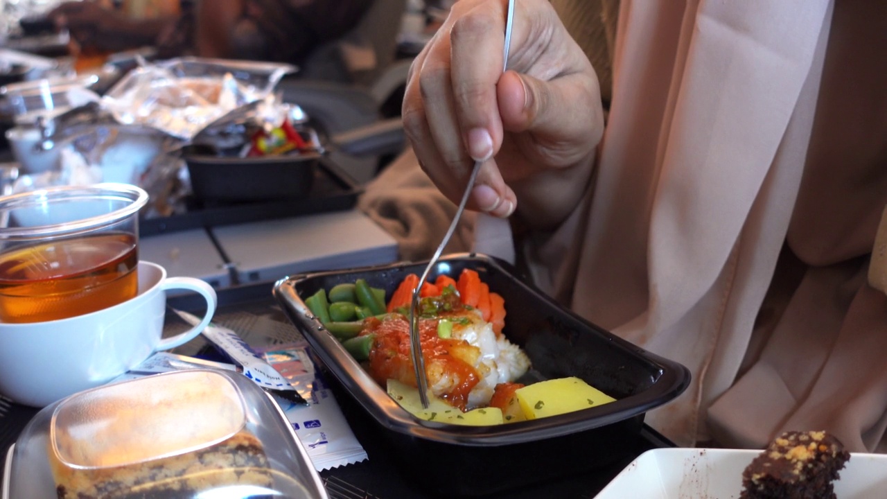 女人在飞机上吃东西。视频素材