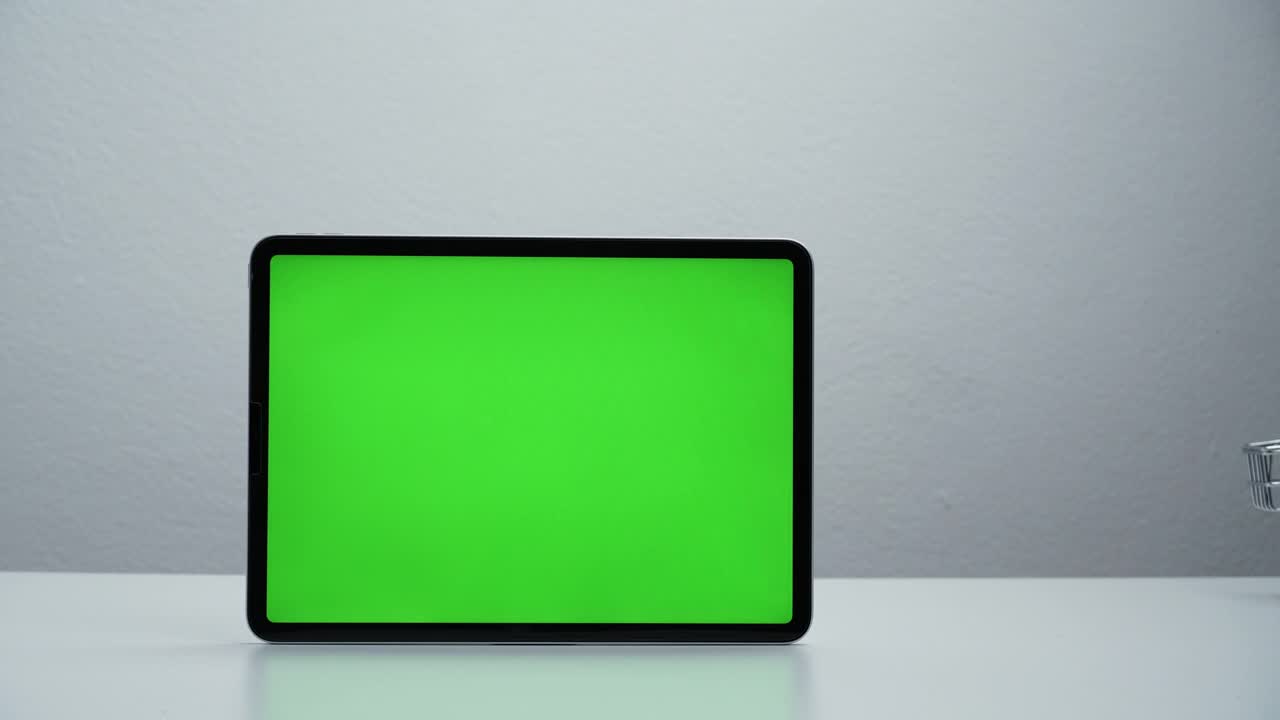 定格动作，购物车上下移动，平板电脑绿色屏幕。视频下载