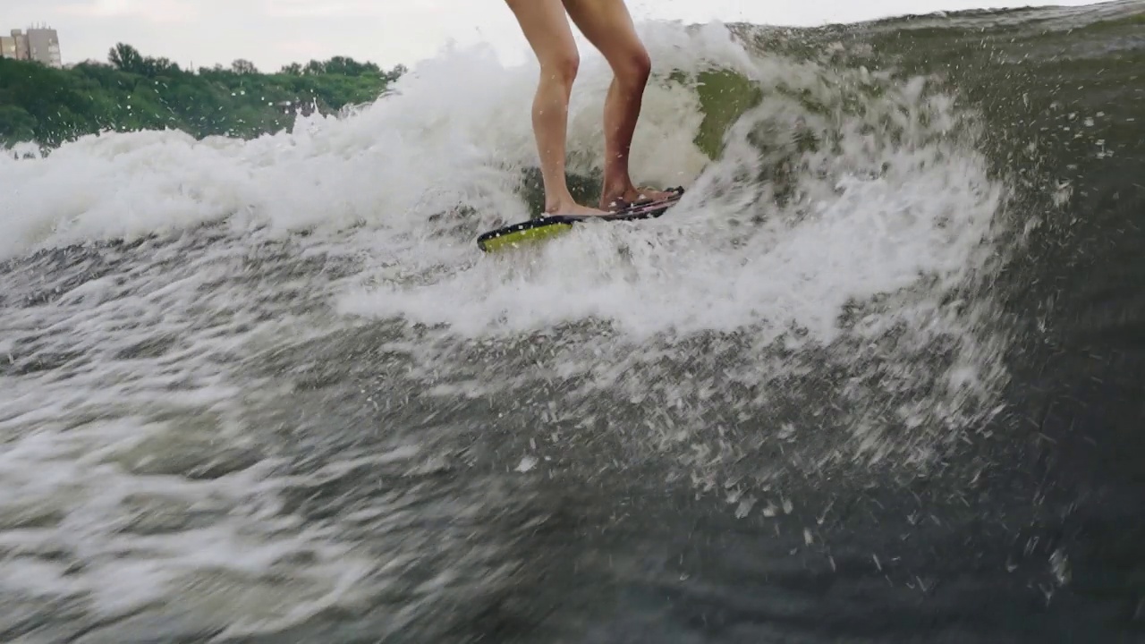 一个女孩在水上滑板上的动态镜头。近距离射击视频素材