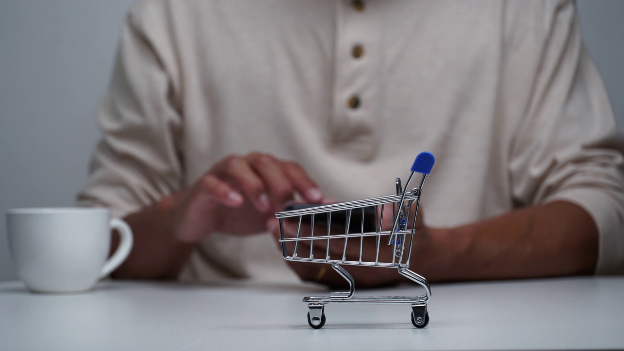 定格动作一个男人用智能手机网购，购物车购物移动。视频下载