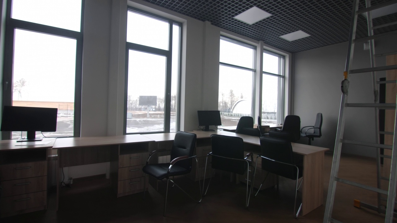 修理后的办公室里有木制办公桌和椅子和电脑视频下载