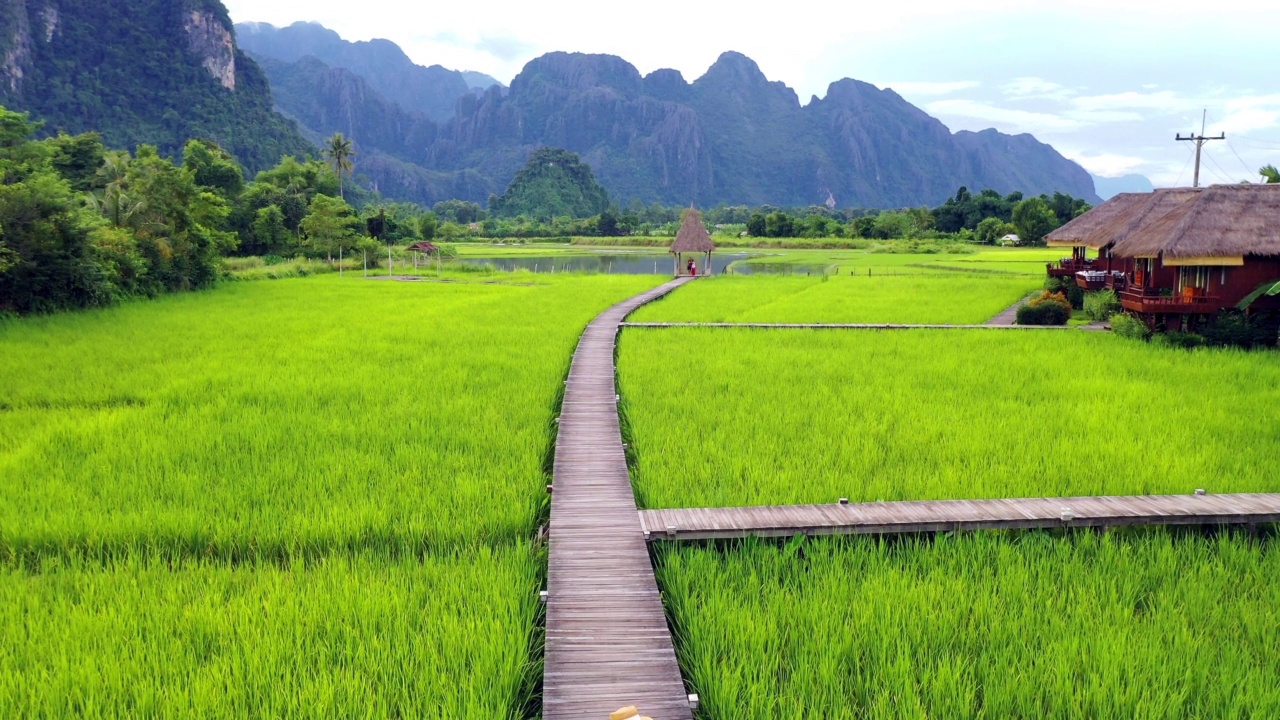 木桥与稻田在山上，白云和天空的背景，美丽的vieeng Tara别墅在万荣，老挝。早上的时间视频下载