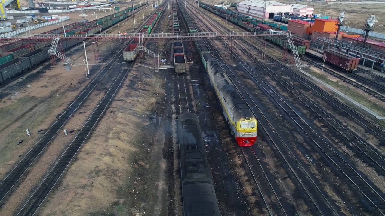 载着运煤列车的火车头正在等待启动许可。柴油机车烟囱冒出的黑烟污染了大气，排放出二氧化碳。鸟瞰图视频素材