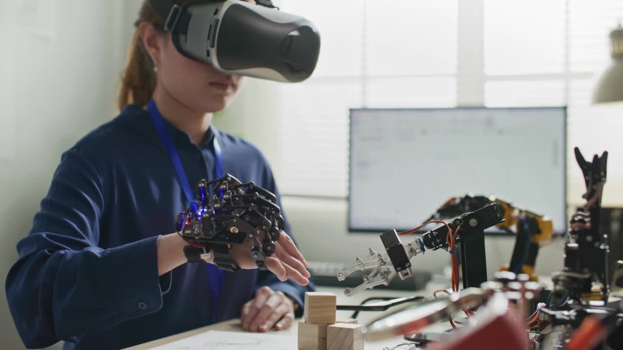 身穿蓝色衬衫的日本专业开发工程师正在用增强现实耳机控制未来机器人手臂视频素材