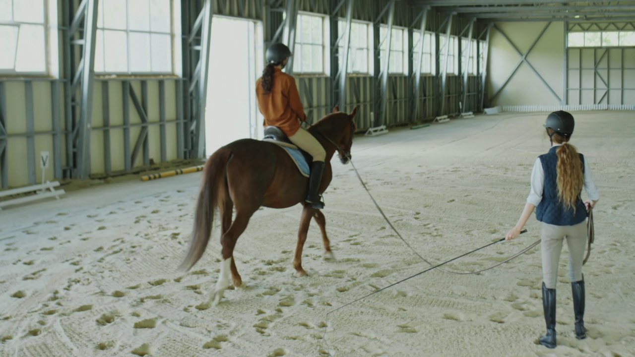 女性学习骑马与专业教练视频素材