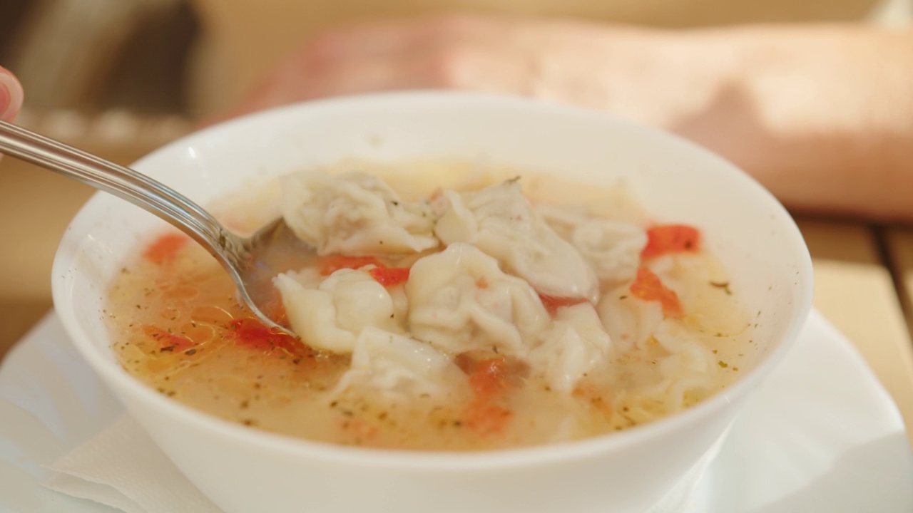 男子午餐喝汤和饺子。中亚和高加索的美食视频下载