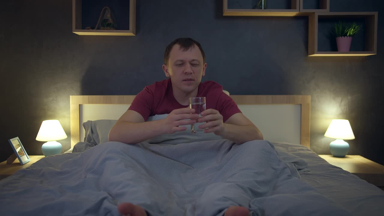 男人睡觉前在床上喝一杯干净的水，正面观景，保健视频下载