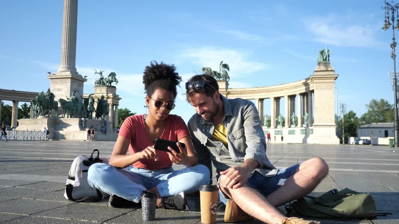 情侣们在夏天旅行，一起在城市里享受假期，用智能手机拍照视频素材