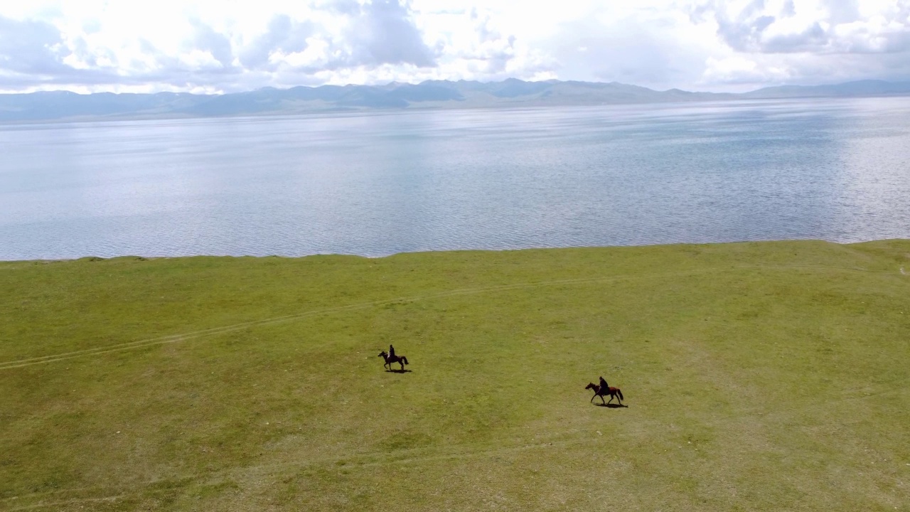 图为，在吉尔吉斯斯坦松库尔湖附近骑马的男子。无人机视频4 k。视频素材