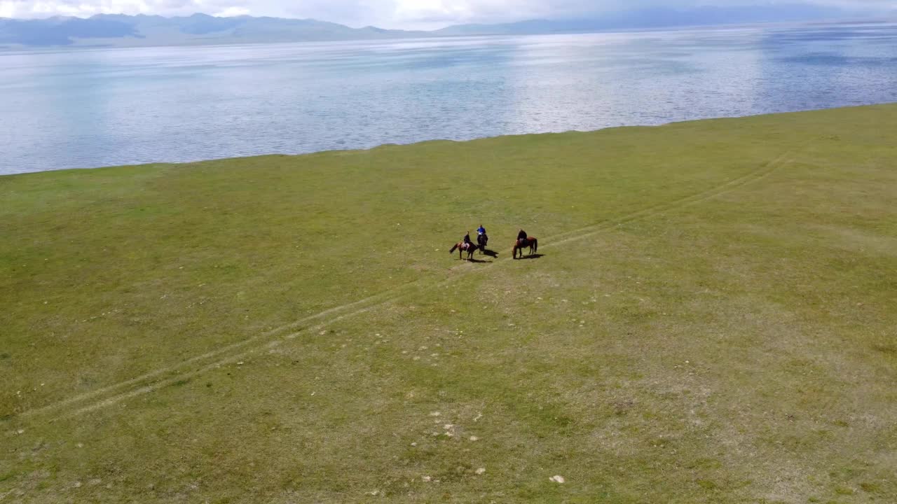 图为，在吉尔吉斯斯坦松库尔湖附近骑马的男子。无人机视频4 k。视频素材