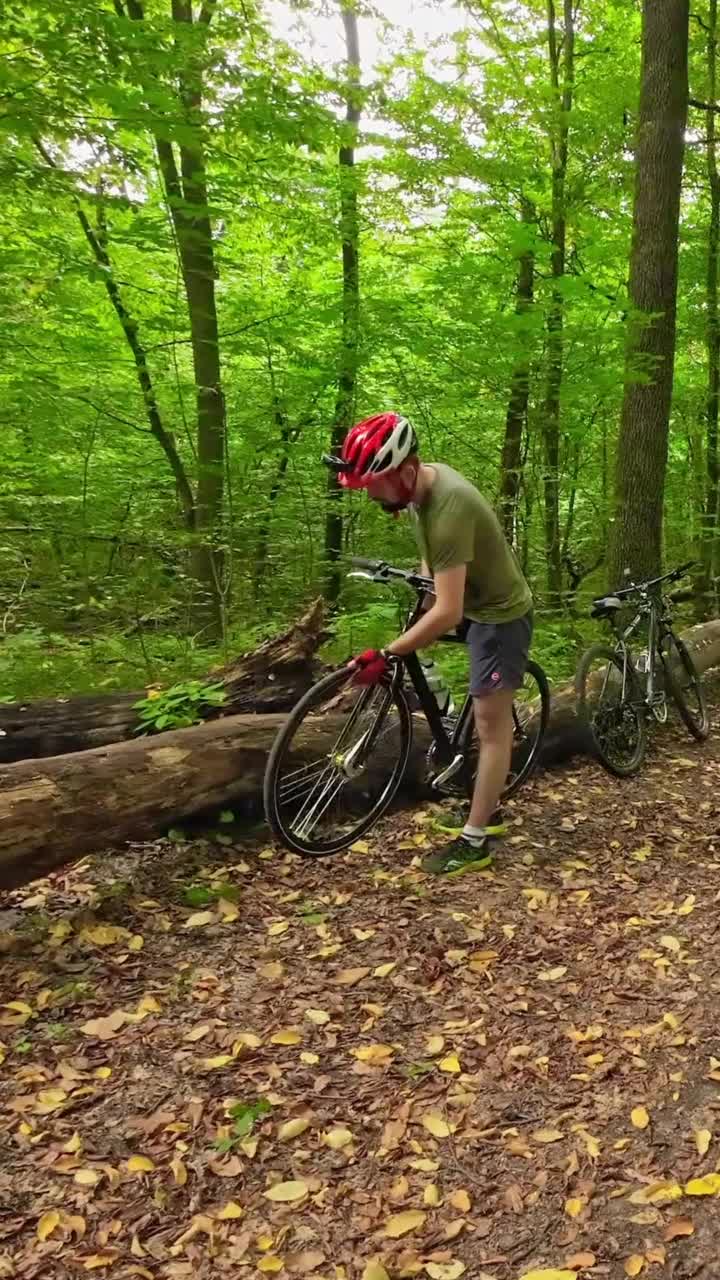 一个戴着防护头盔的男人骑着他的自行车在绿林夏日里骑自行车。视频素材