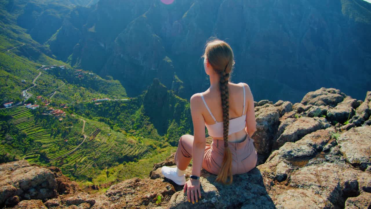 马斯卡峡谷和特内里费岛的村庄。米拉多·拉·克鲁兹·德·希尔达。年轻女子坐在视角欣赏马斯卡峡谷热带自然景观。西班牙加纳利群岛。Teno乡村公园。视频素材