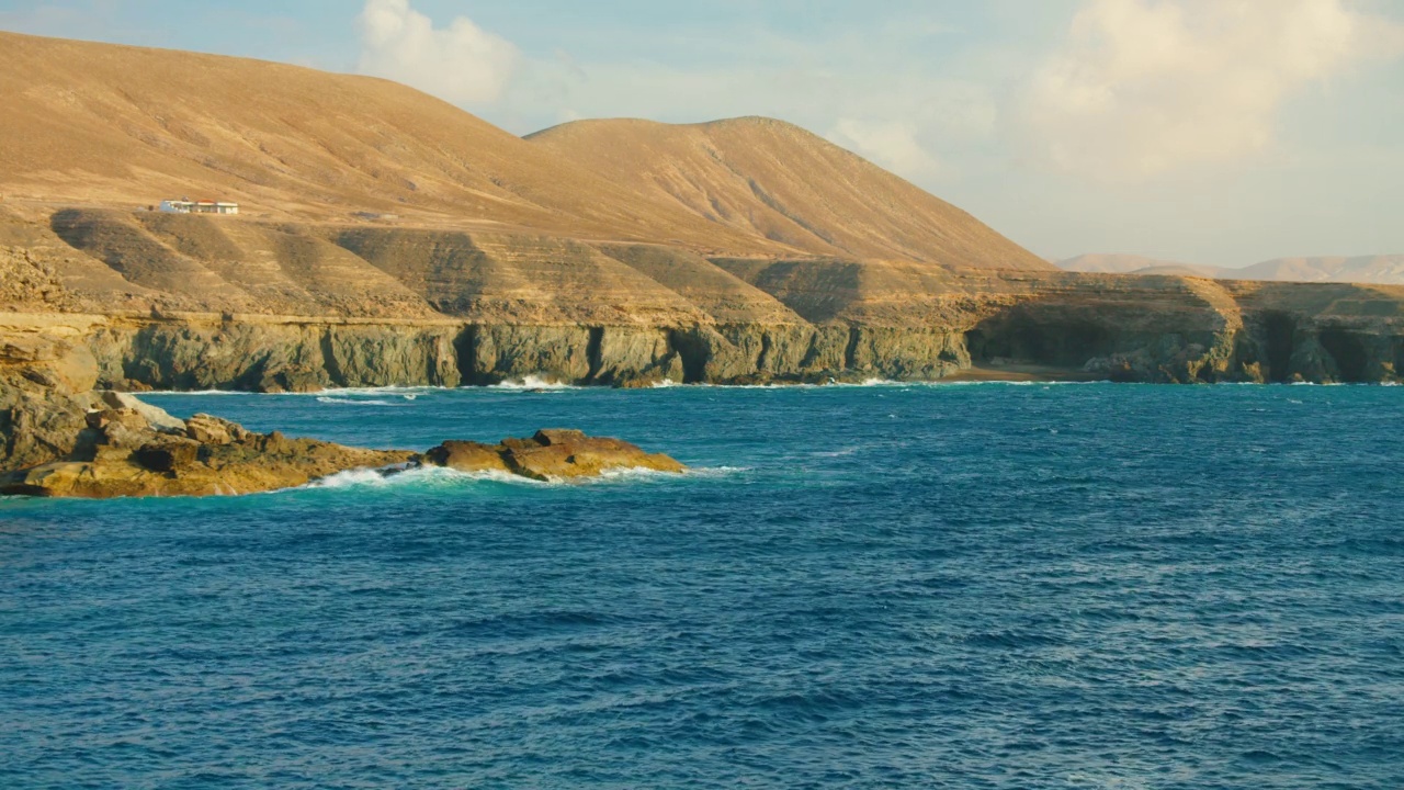 旅游目的地。西班牙加那利群岛富埃特文图拉的阿朱伊镇的岩石和悬崖。蔚蓝平静的海浪。Picteresque壮观的4k电影拍摄。视频下载