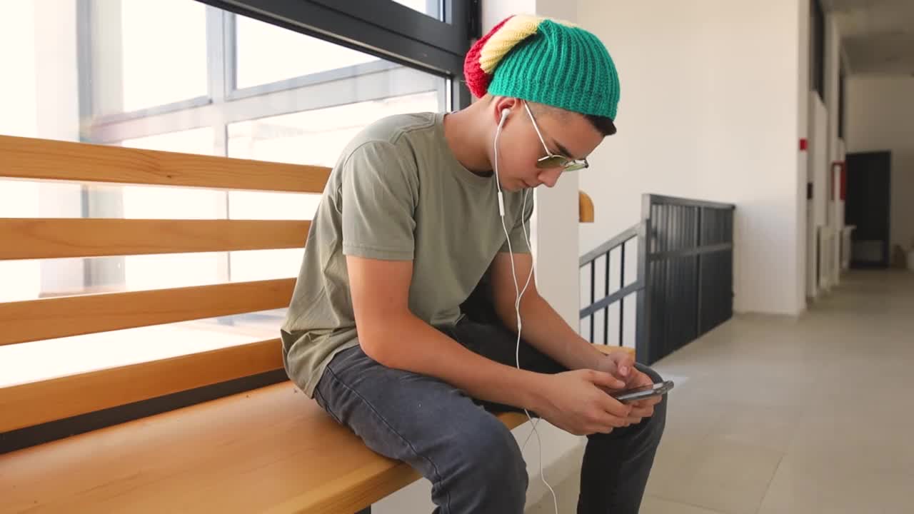 一名男生在学校走廊上使用手机视频素材