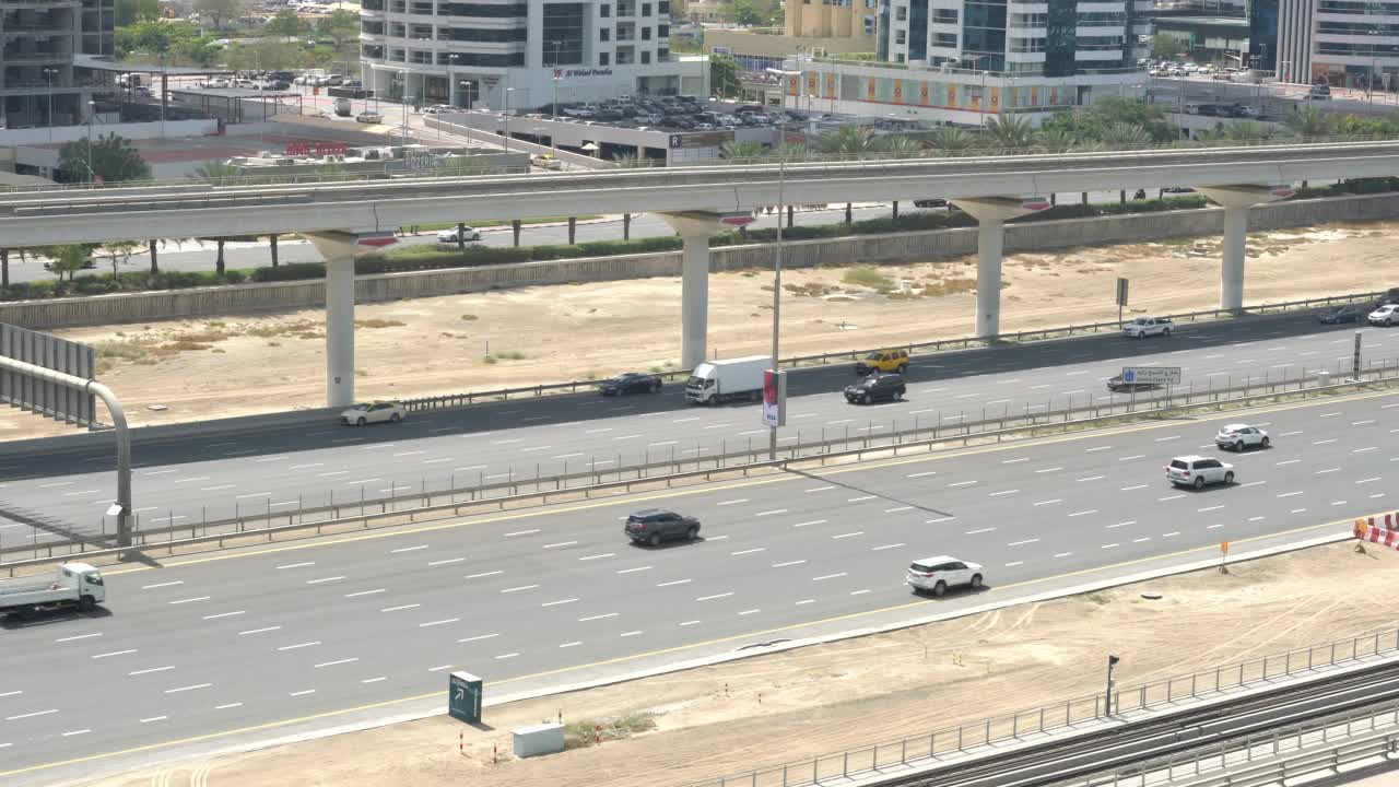 俯瞰迪拜主要高速公路的车道。汽车和地铁在Sheikh Zayed路上行驶视频素材