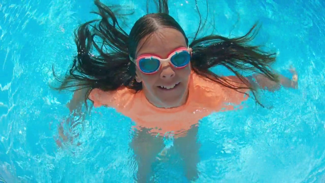 小女孩在度假村的游泳池里玩。视频下载
