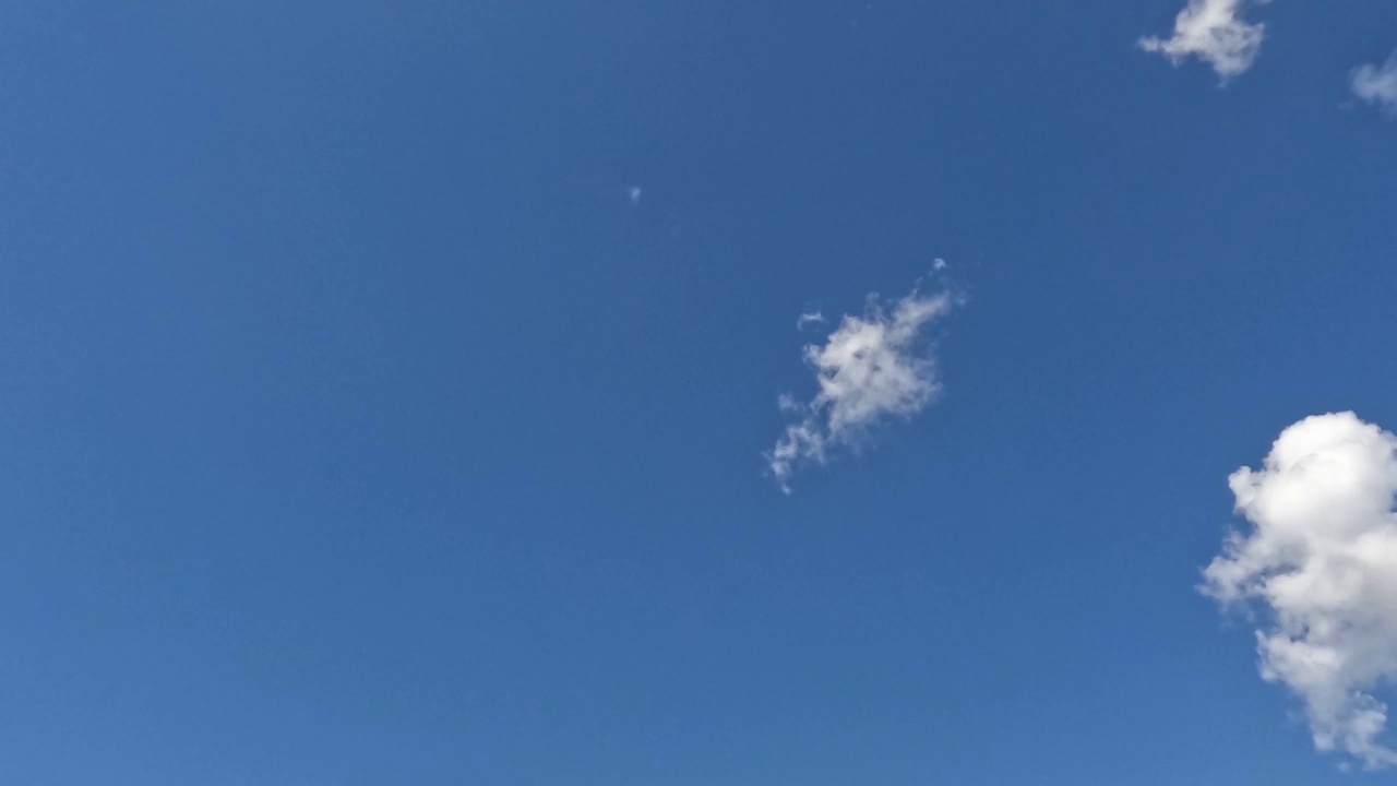 一朵朵时间流逝的小白云出现在蓝天上，然后在晴天消失。视频下载