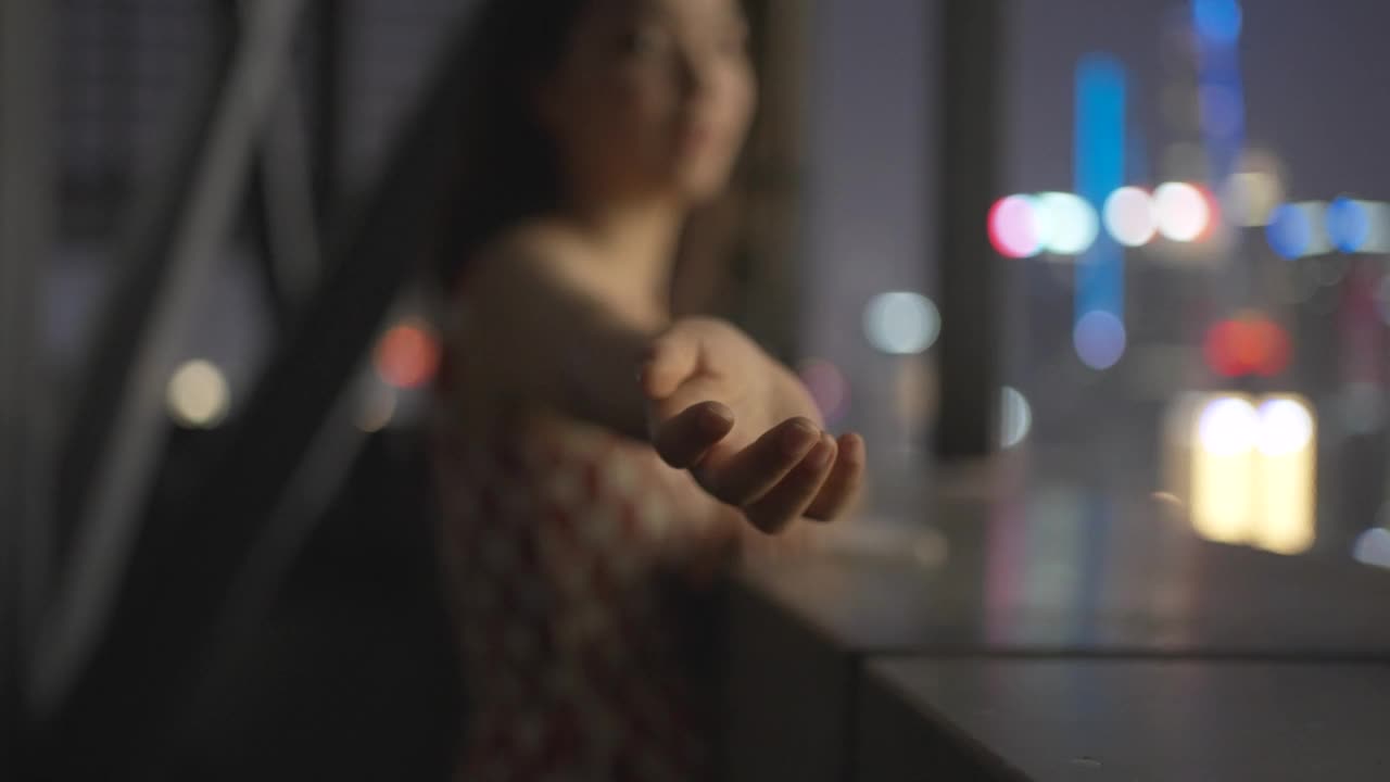 年轻女子在城市中使用平板设备，站在窗前视频下载