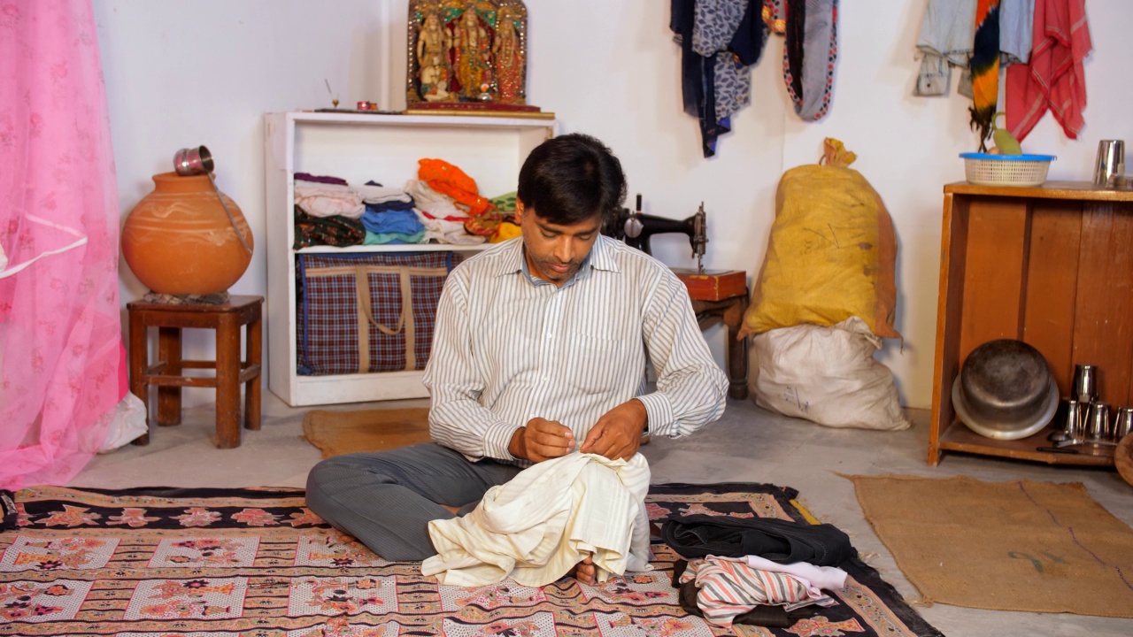 一个穷人用线和针缝制他的衬衫——裁缝，职业，当地的工匠，打工者，日薪工人视频素材