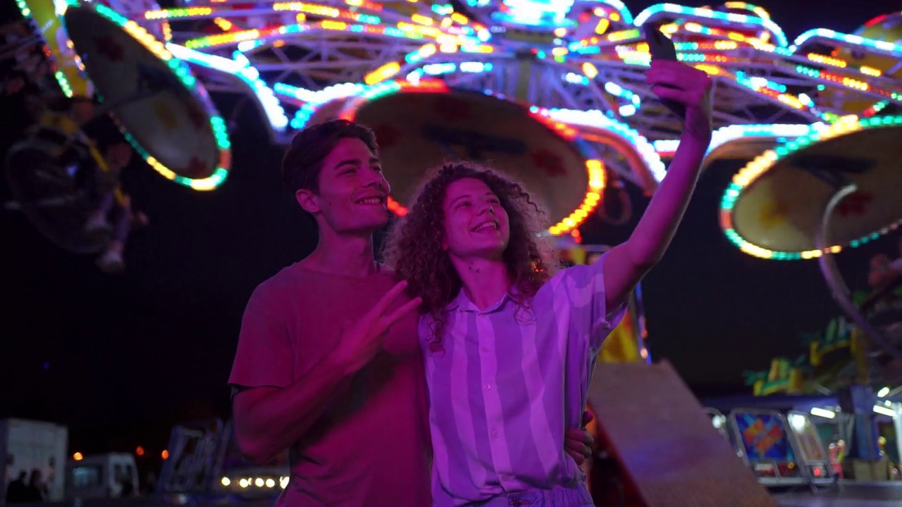 一对年轻情侣在游乐场自拍视频素材