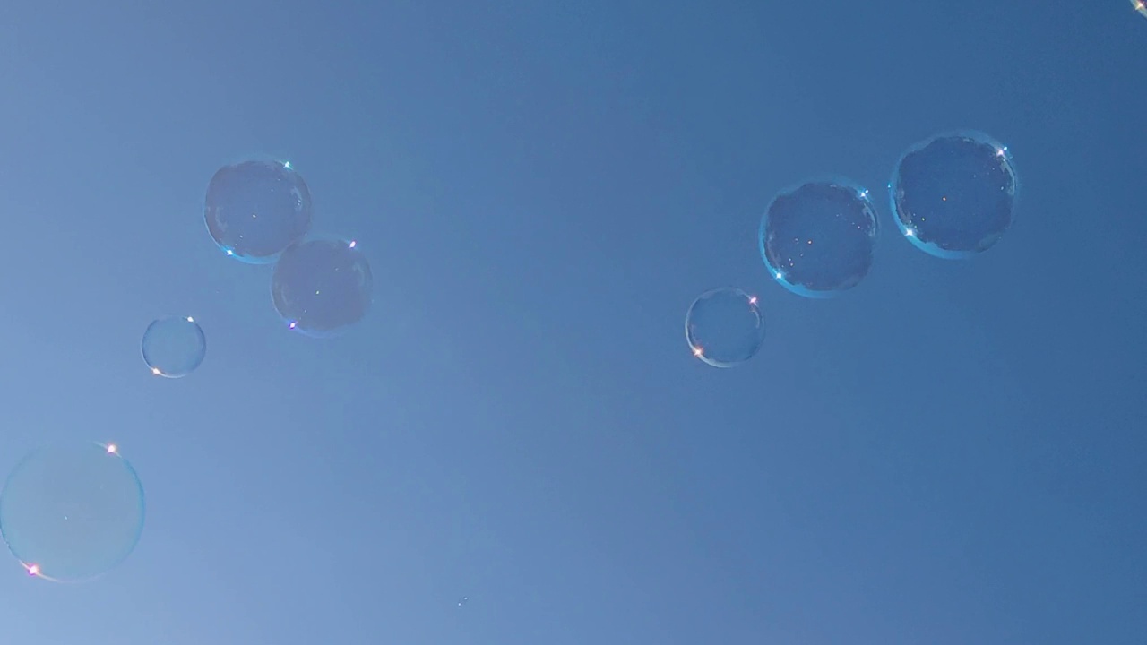 几个半透明气泡在蓝天下漂浮在空中的动画。色彩和运动概念。视频下载
