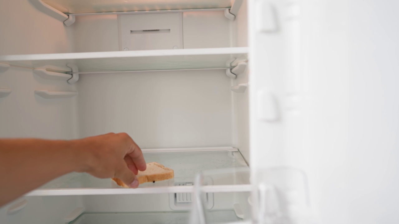 饥饿的人打开空冰箱，拿走剩下的面包。视频下载