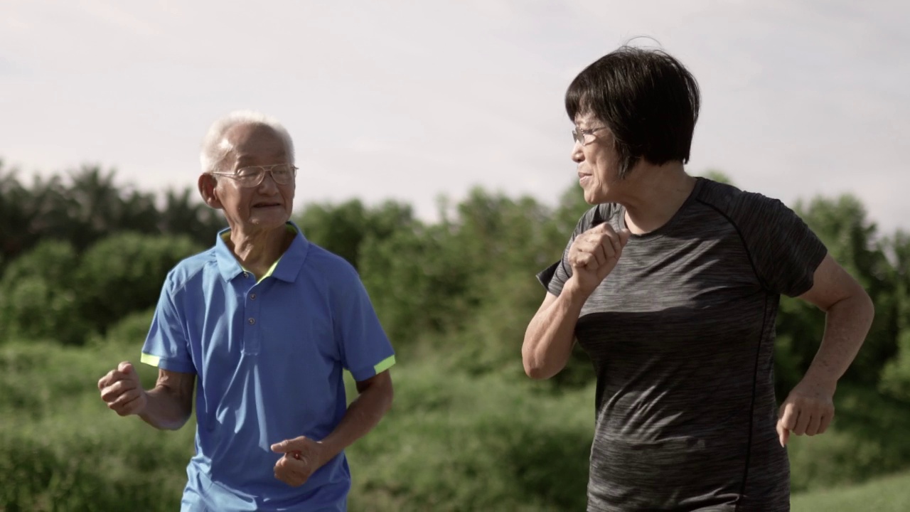 2对亚洲华人老年夫妇早上在公园慢跑视频素材