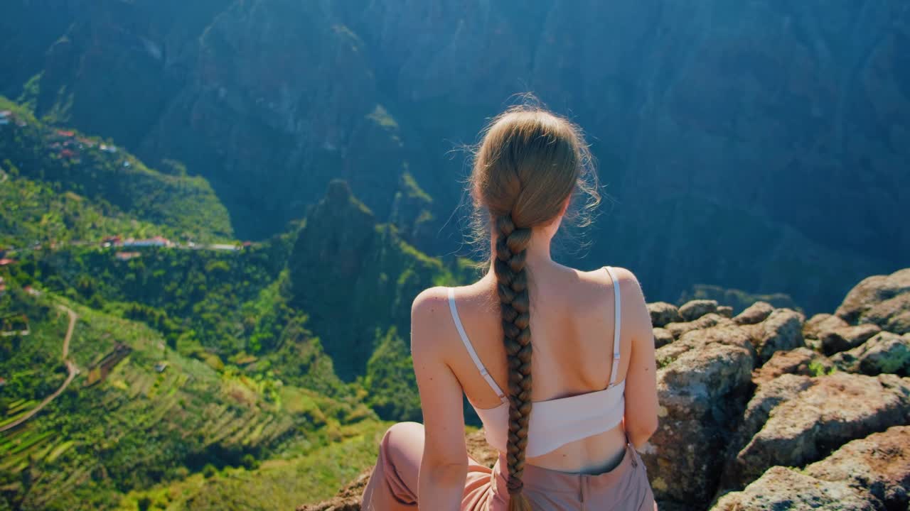 马斯卡峡谷和特内里费岛的村庄。阳光明媚的日子里，年轻女子坐在观景台上欣赏马斯卡峡谷热带自然景观。美丽的风景。去西班牙。视频素材