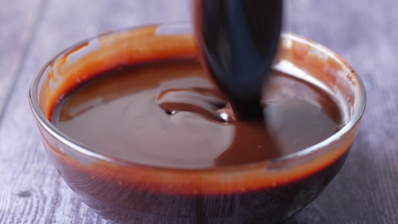 黑巧克力奶油在一个碗里，在白色的视频下载