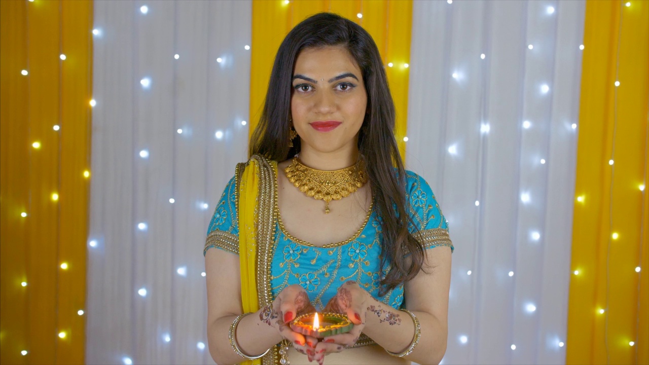 Bokeh拍摄-一个美丽的年轻女性举行燃烧Diya排灯节视频素材