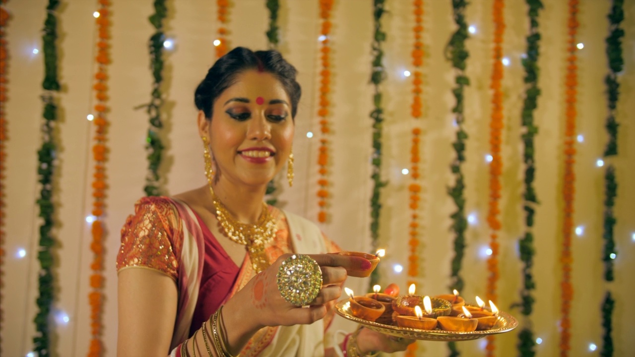 一个漂亮的孟加拉妻子拿着小瓦灯庆祝排灯节视频素材