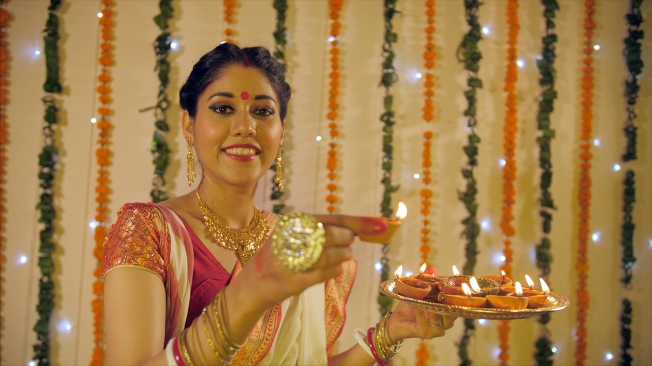 一位印度孟加拉妻子点燃传统的土灯庆祝迪帕瓦节视频素材