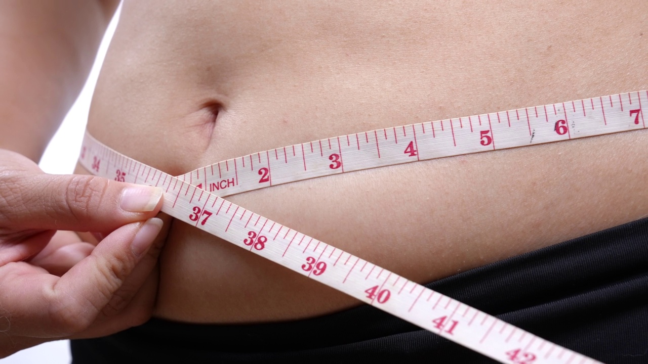 超重的女人在测量她的腹部视频素材
