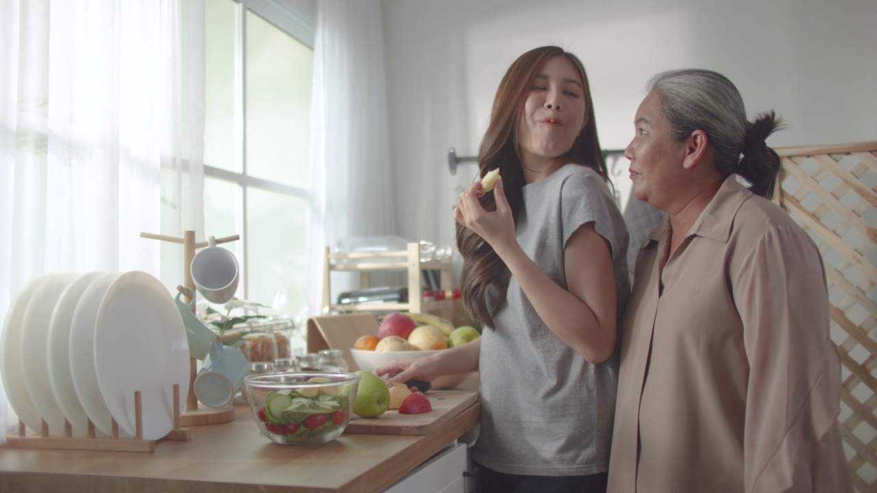 亚洲华人美女和她的母亲准备做饭的家庭在厨房柜台视频素材
