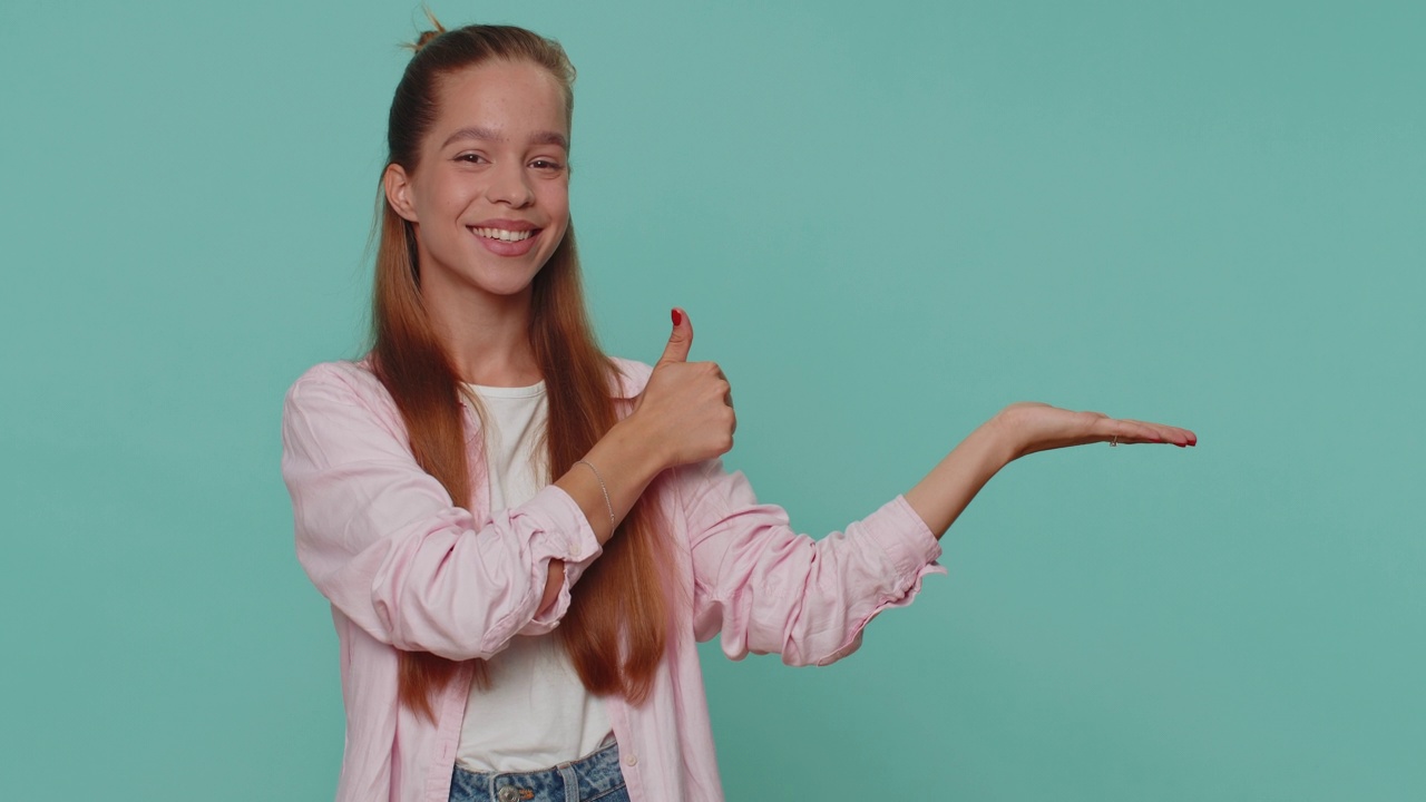 女孩竖起大拇指，指着右边空白的地方，广告区域的商业文字，标志视频素材