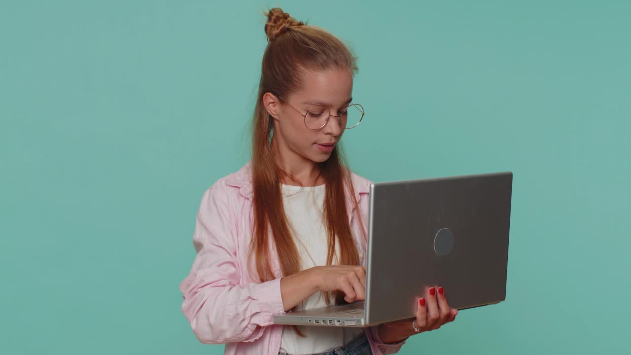 一个女孩在笔记本电脑上上网，对着镜头竖起大拇指，积极的反馈，比如，彩票中奖视频素材