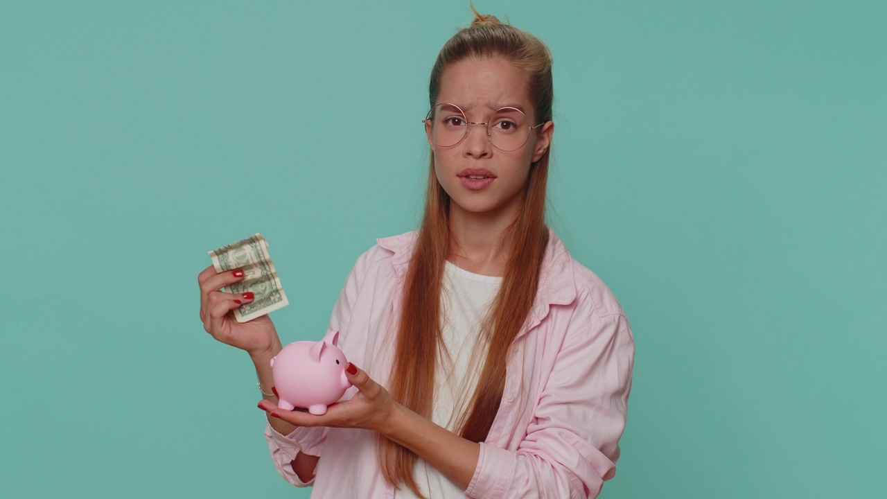 可怜的少女拿着储蓄罐和一元钞票，金融危机，破产，债务，失败视频素材