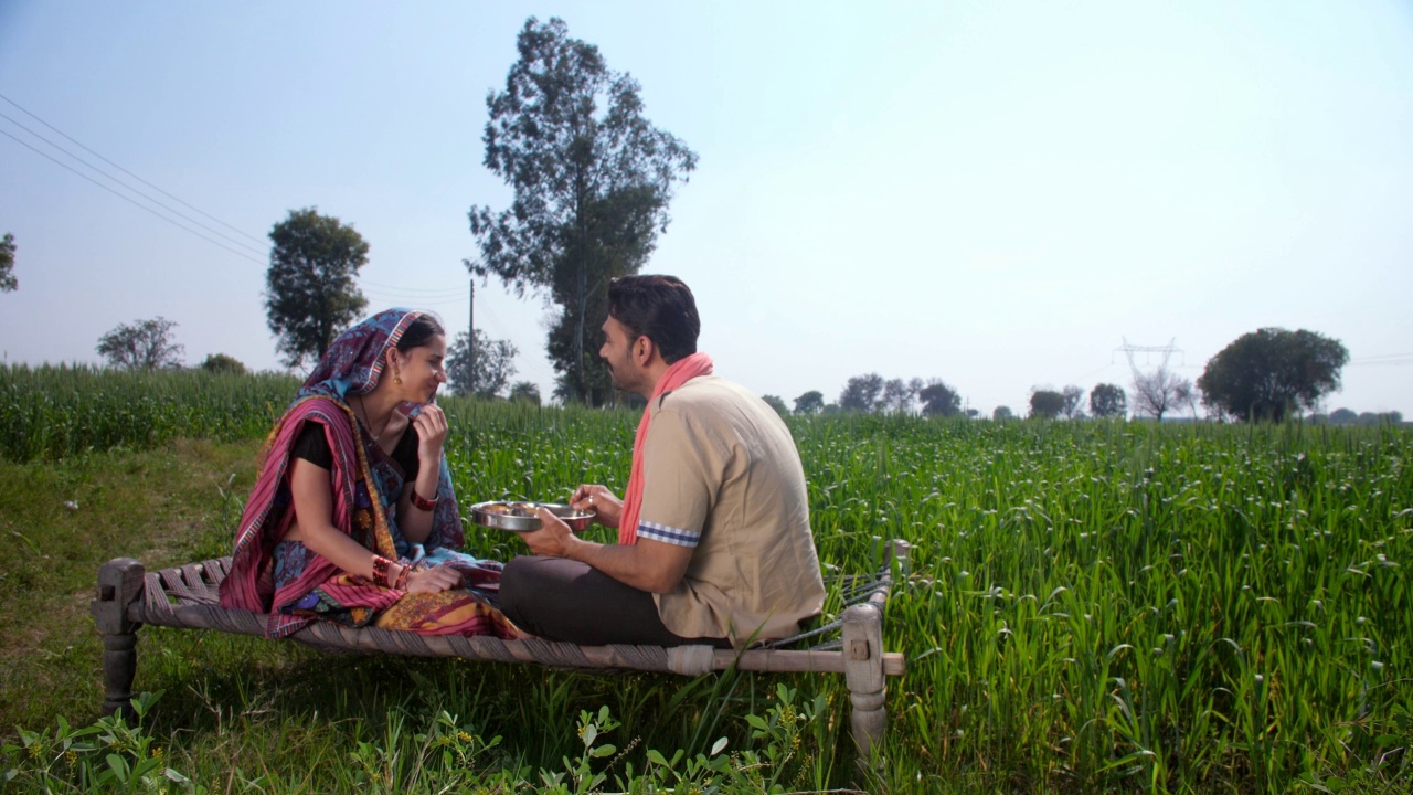 一个中年乡村丈夫正在喂他美丽的妻子——印度乡村的场景，美味的食物，关系和纽带视频素材