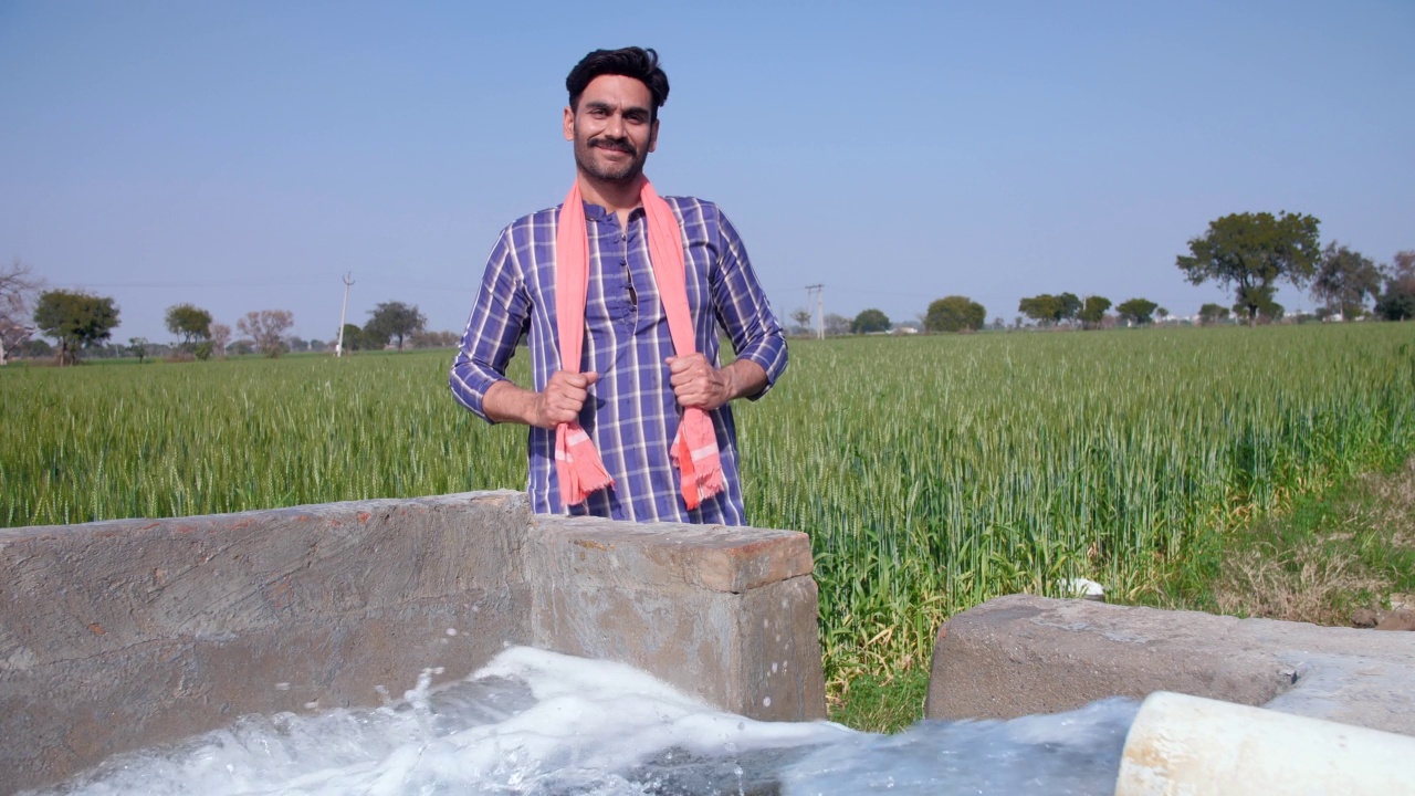 一个自信的大胡子农民抱着双臂站在一个管道井旁——休闲，放松视频素材