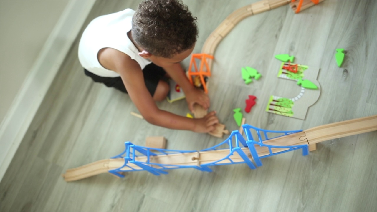 火车套装，男孩玩火车套装建造轨道在头顶视频下载