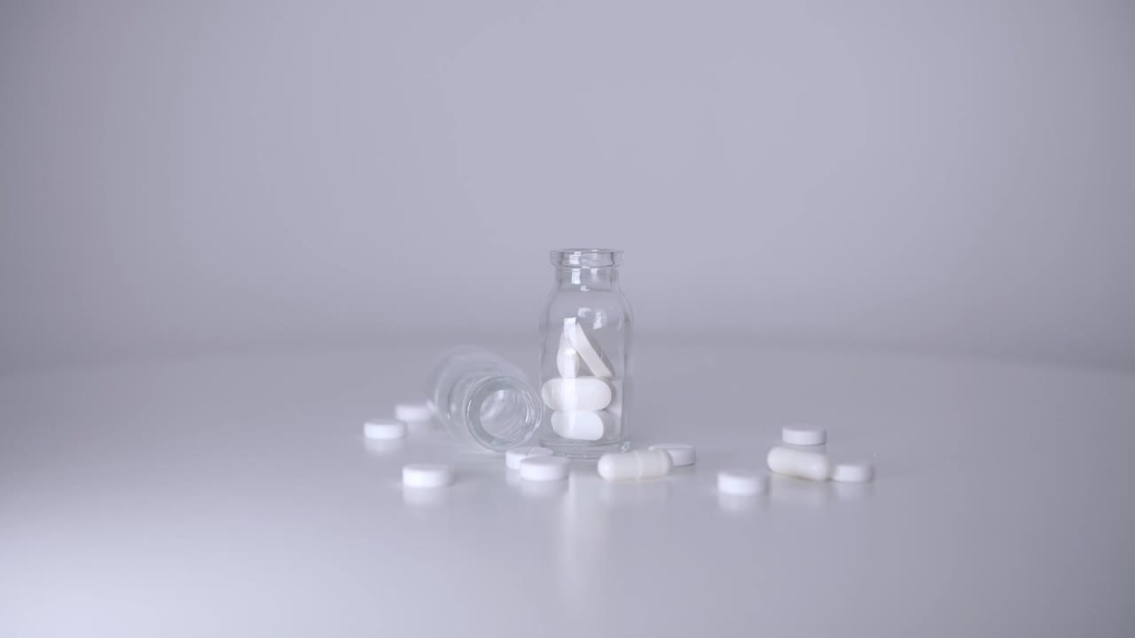 药丸从上面落到一个透明的罐子里视频素材