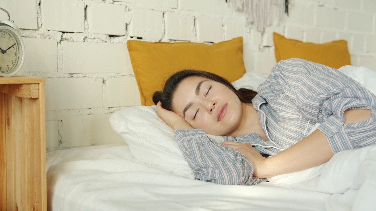 美丽的亚洲女士的肖像睡在床上独自穿着睡衣视频下载
