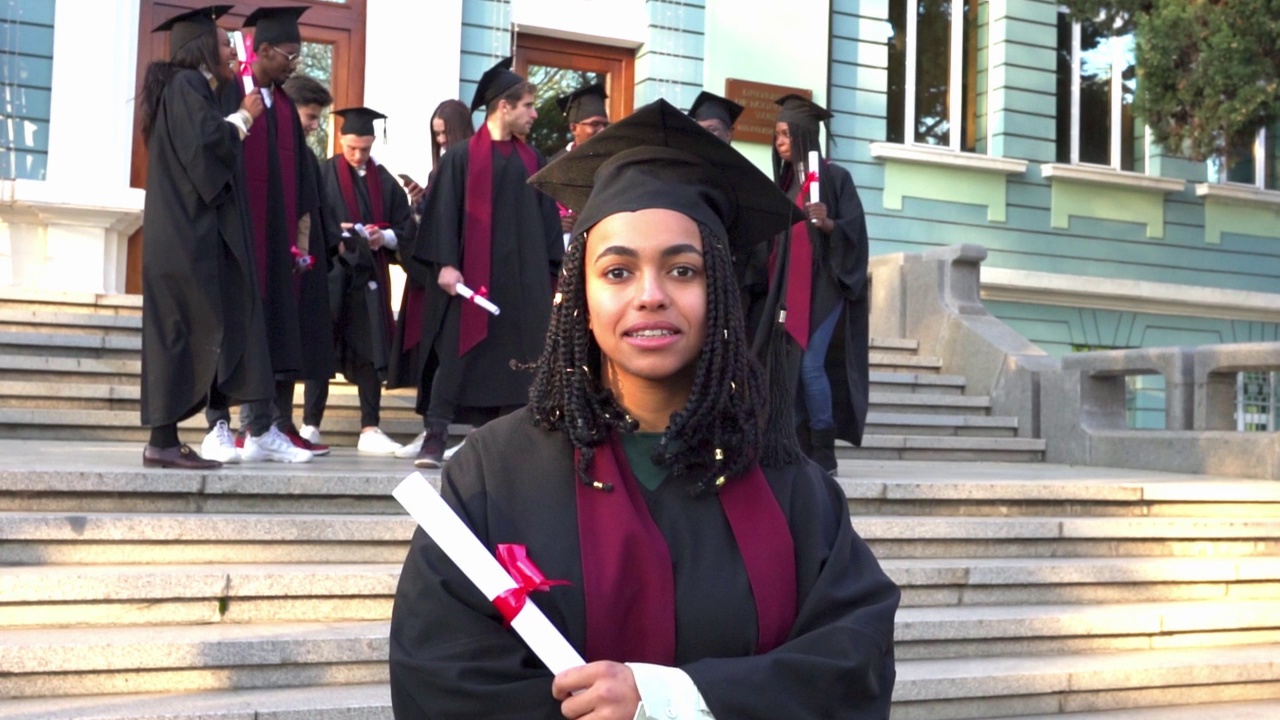 一位拿着毕业证书站着的女学者视频素材